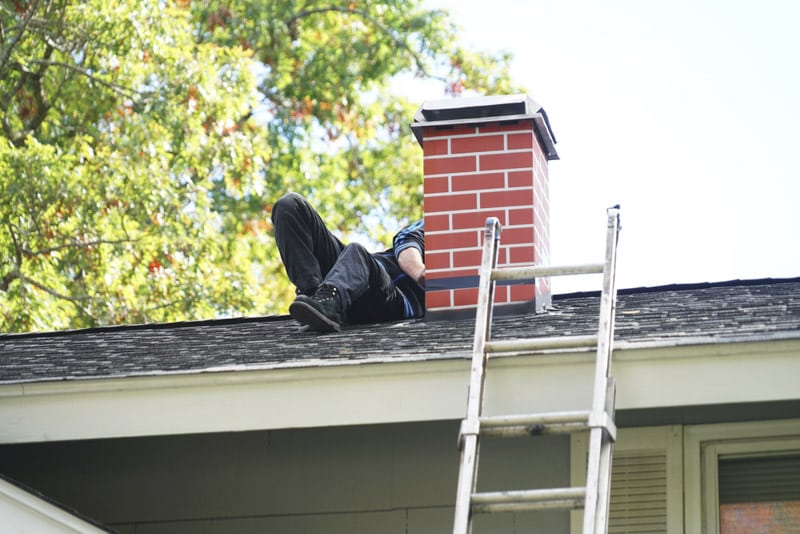 WorkerRepairingChimneyOnTheRoof - Chimney Sweeps of America chimney inspection in Denver, Chimney Sweeps Of America